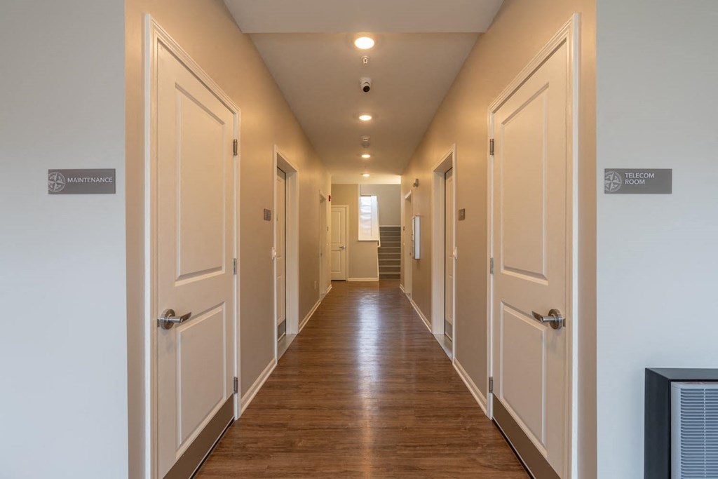 a hallway with white doors and a wood floor
