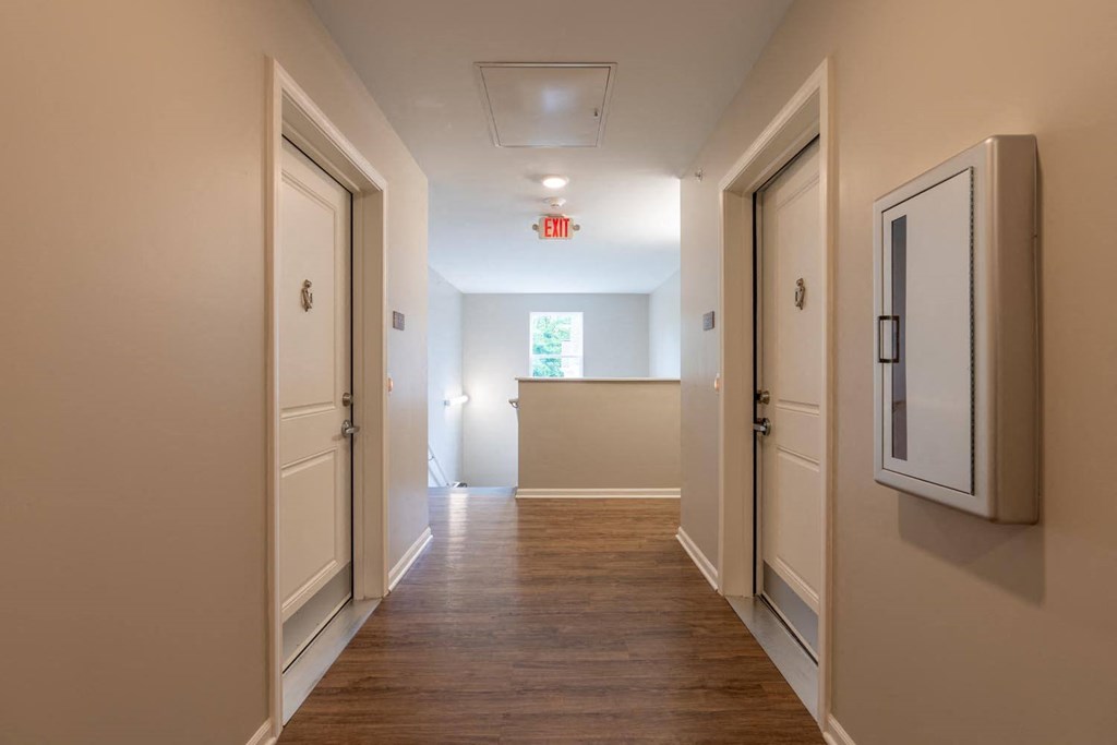 a hallway with white doors and a wood floor