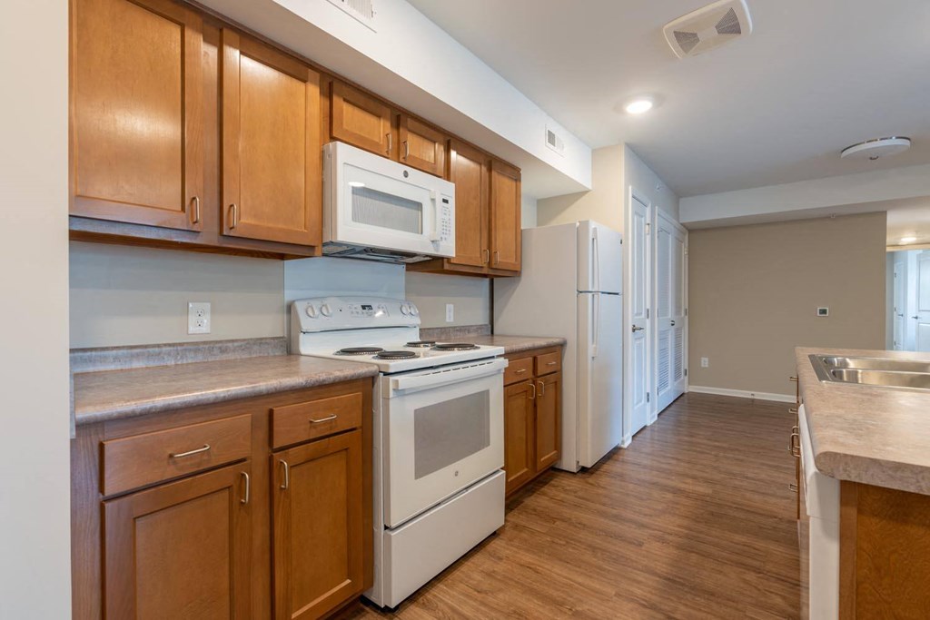 a kitchen with white appliances and wooden cabinets