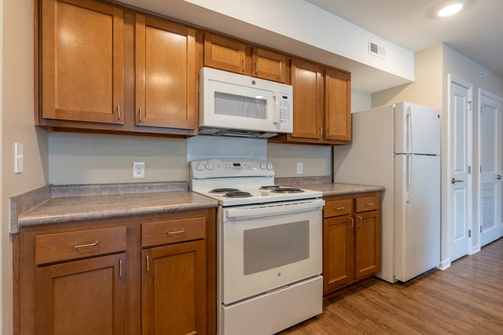 a kitchen with white appliances and wooden cabinets