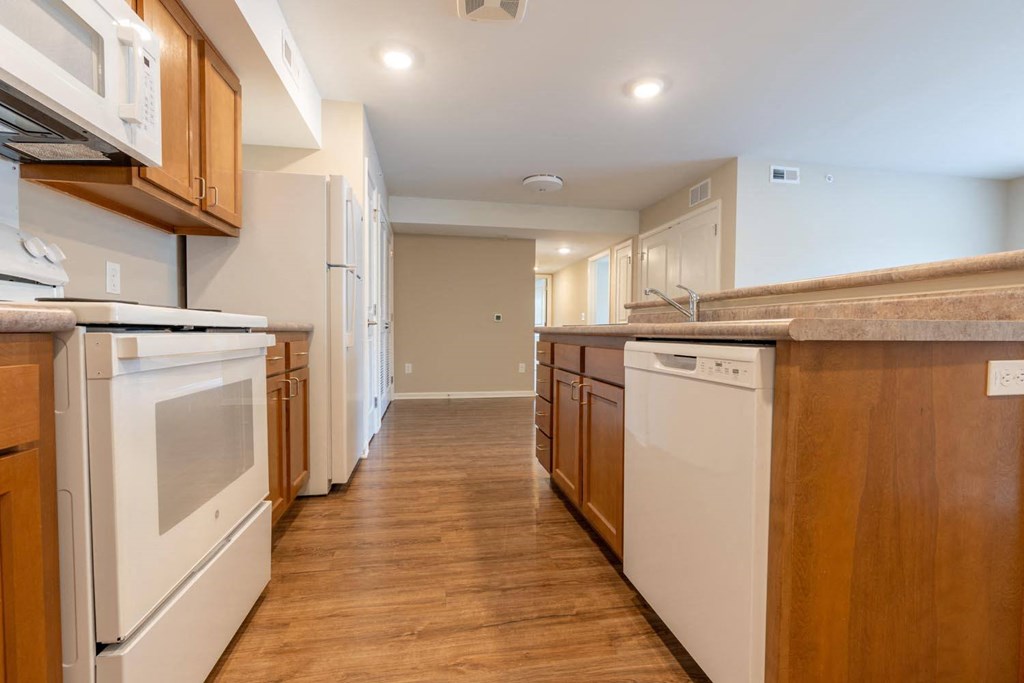 a kitchen with white appliances and wooden cabinets