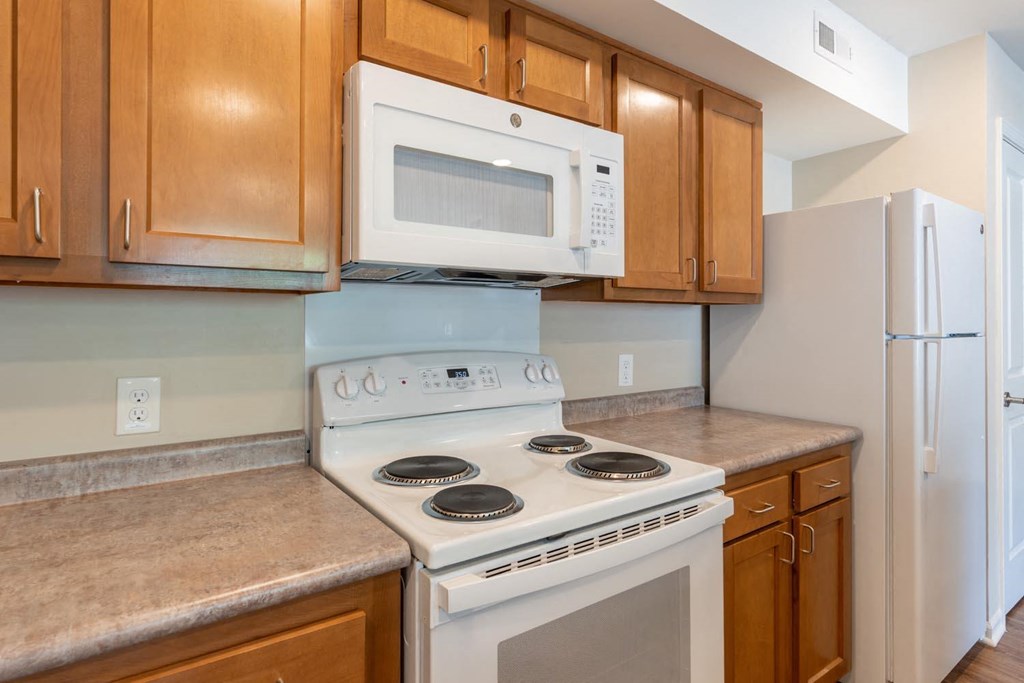 a kitchen with white appliances and wooden cabinets