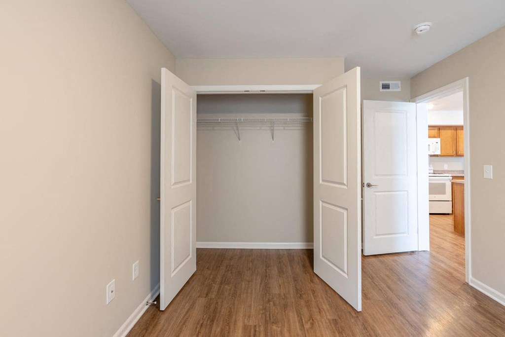 a empty bedroom with a closet and a door to a bathroom