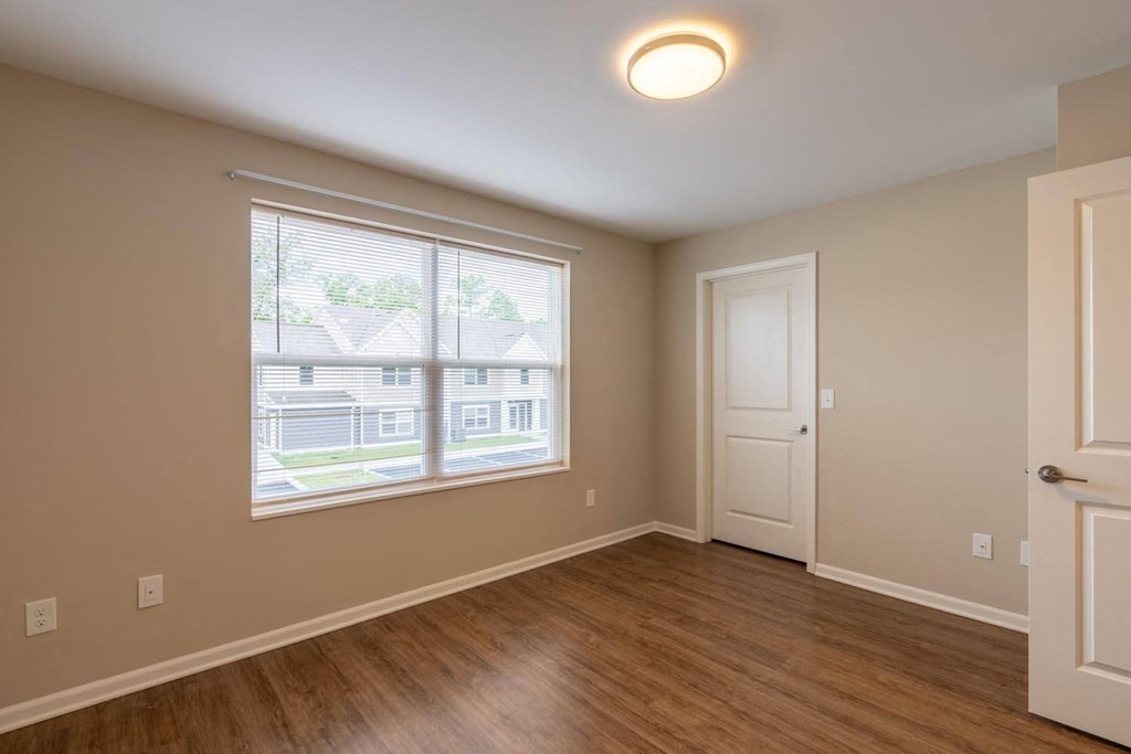 an empty living room with a window and a door