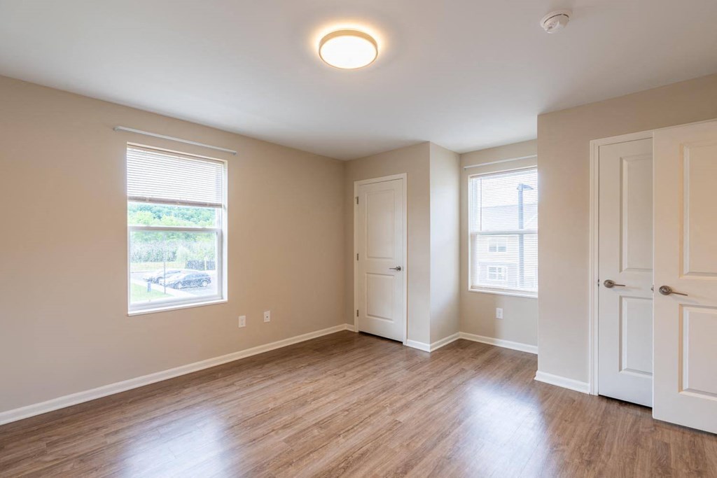 an empty living room with wood floors and white doors