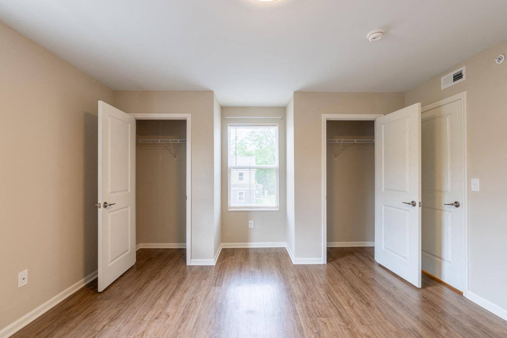 an empty room with three closets and a window