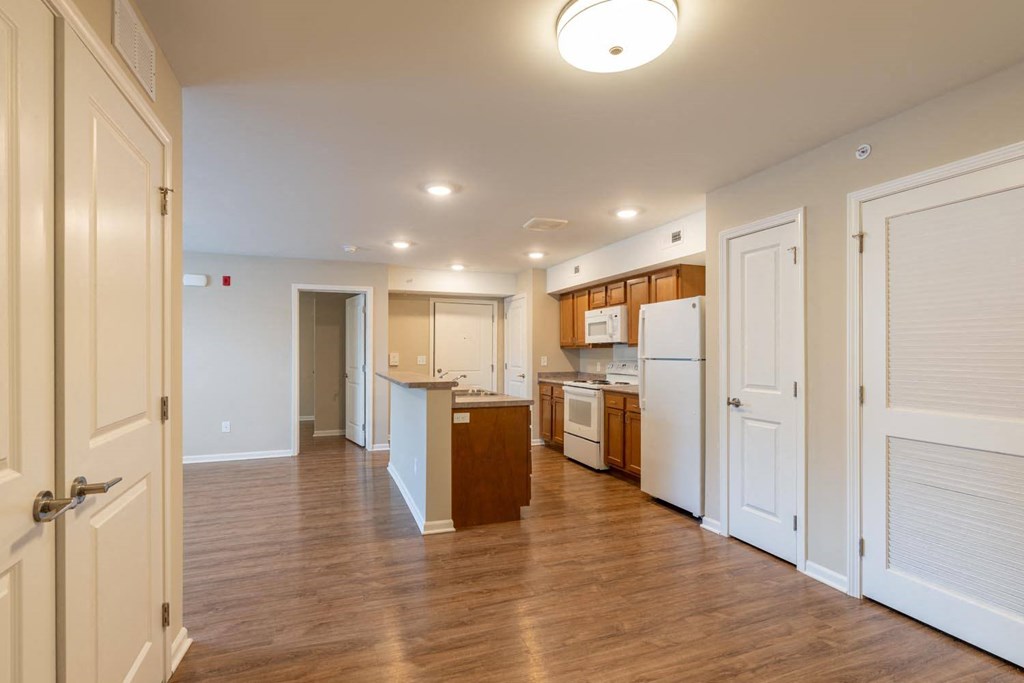 a renovated kitchen with white appliances and wood floors