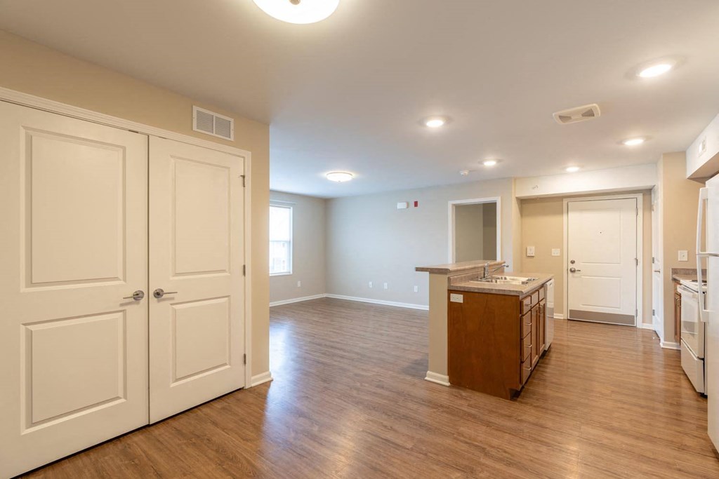 an empty kitchen and living room with white doors