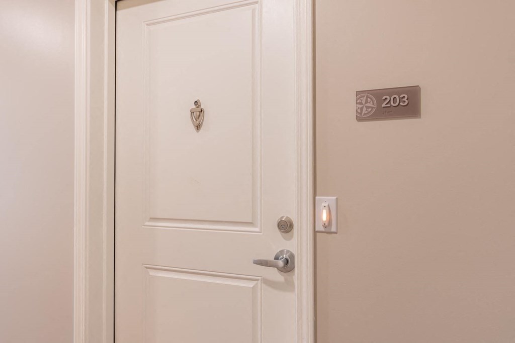a white door with a door knob and a door sign