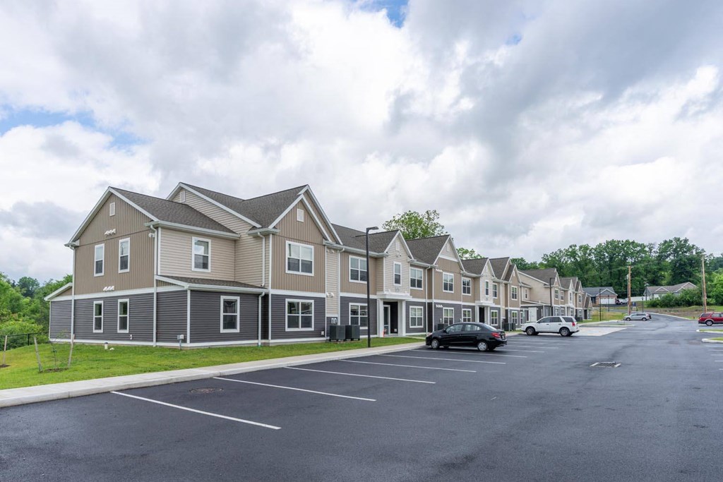 a parking lot with cars in front of a row of houses