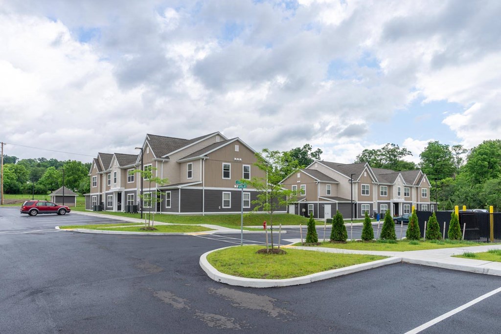 a row of houses on a street corner with a red car