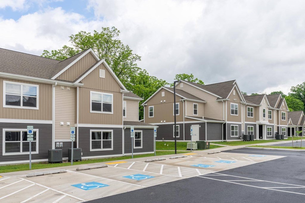 an empty parking lot in front of a row of houses