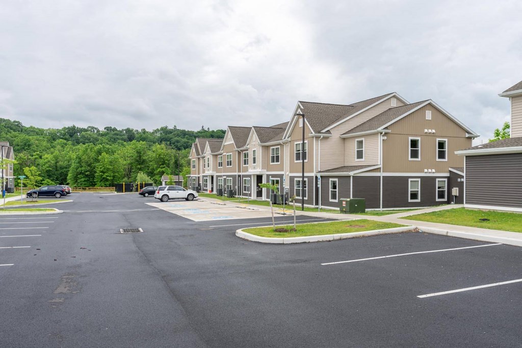 a street with houses in front of a parking lot