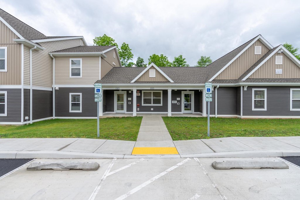 the front of a house with a driveway and lawn