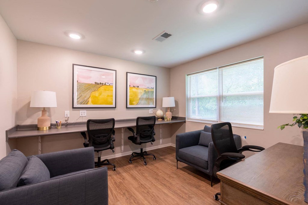 an office with a desk and chairs and a couch