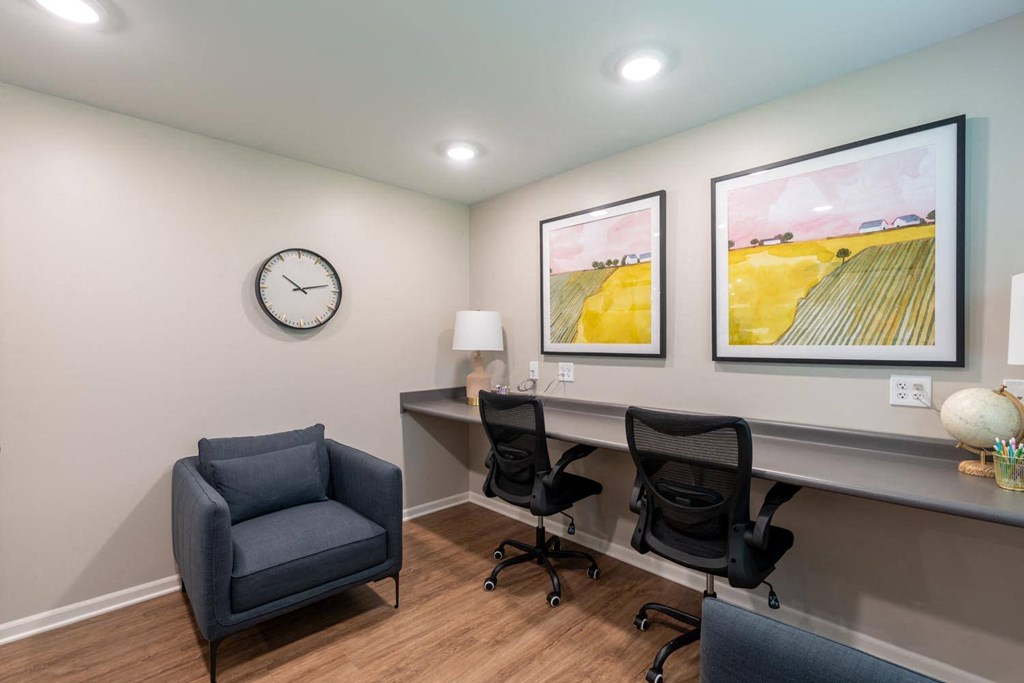 a home office with a desk and chairs and a clock