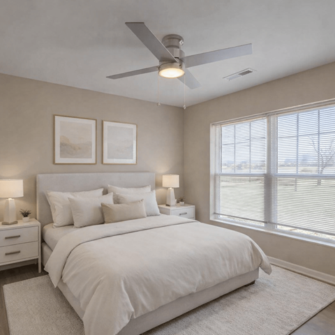 A bedroom with a large bed and a ceiling fan.