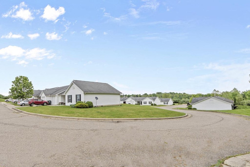 a neighborhood of white houses with a roundabout in the middle