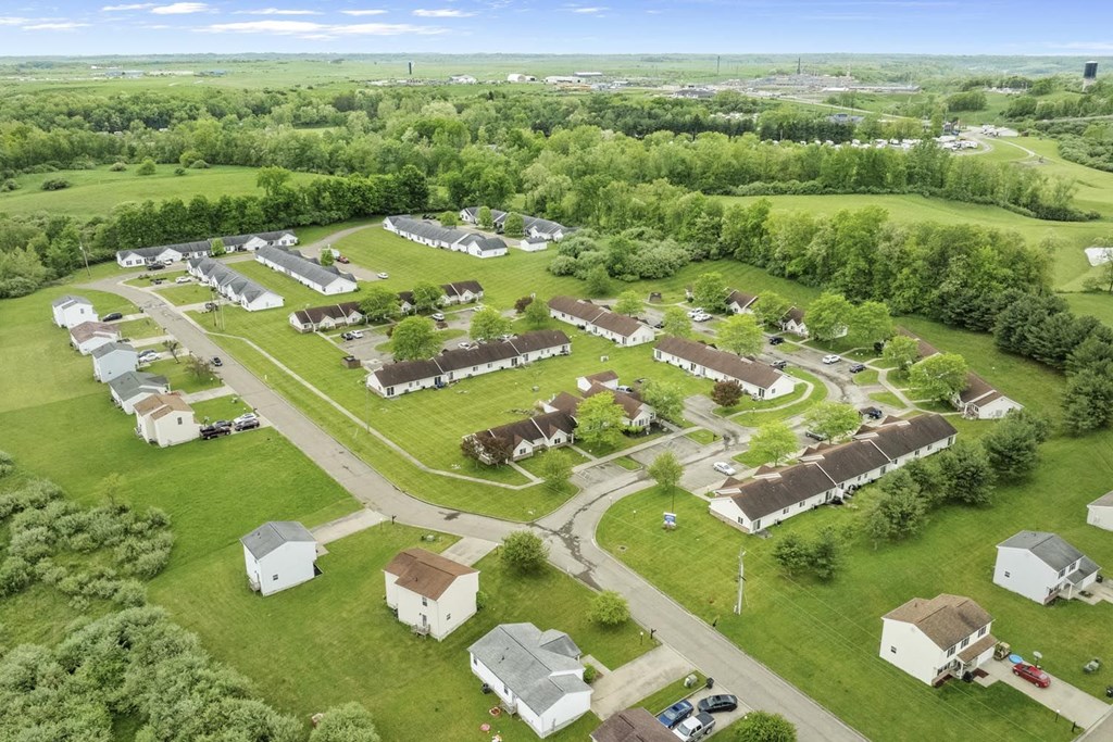 an aerial view of a neighborhood of houses and cars parked in a field