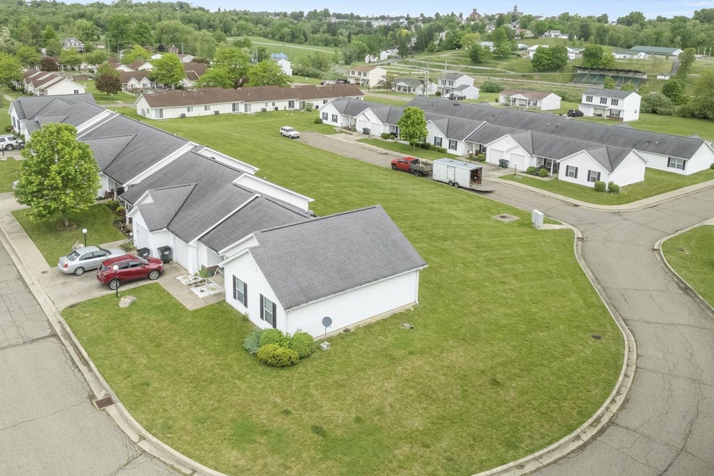 an aerial view of a white house in a neighborhood
