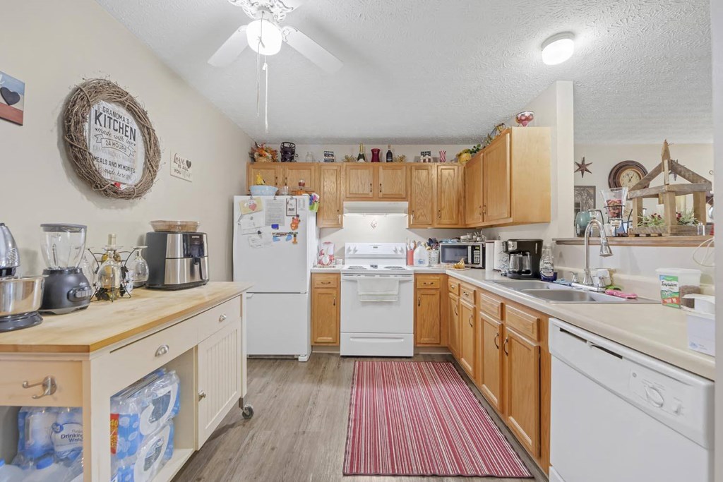 a kitchen with white appliances and wooden cabinets