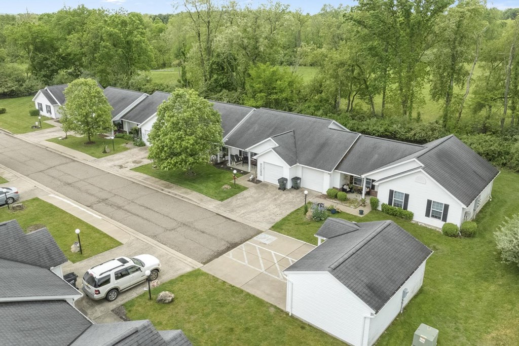 an aerial view of a neighborhood of white houses with gray roofs