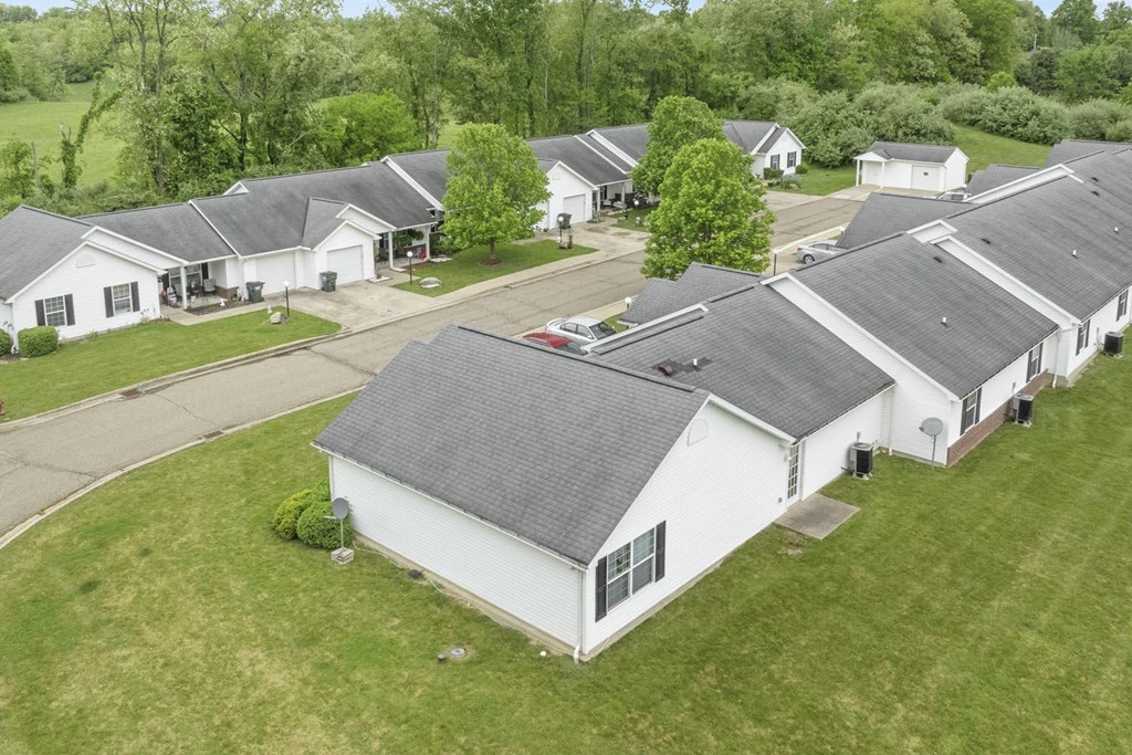 an aerial view of a neighborhood of white houses with gray roofs