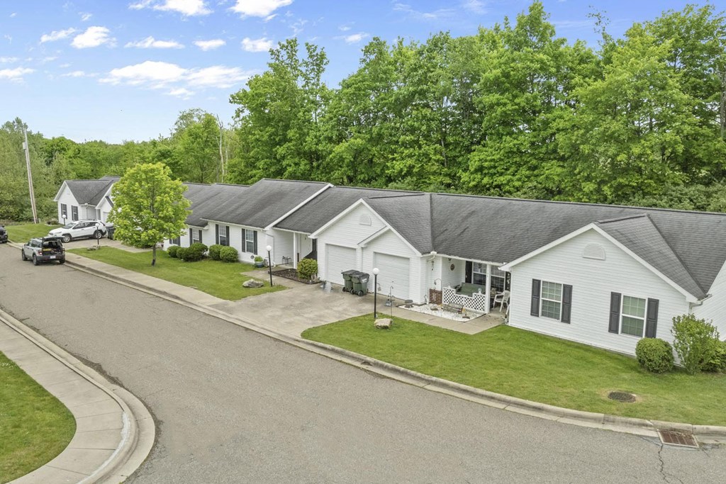 a neighborhood of white houses with gray roofs and a street