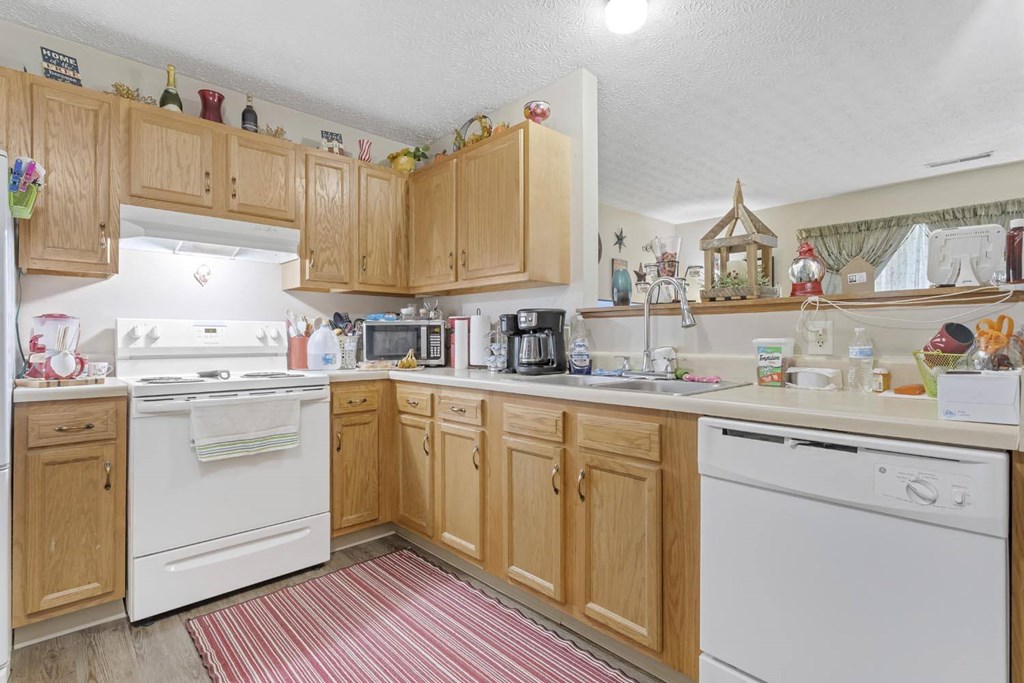 a kitchen with white appliances and wooden cabinets
