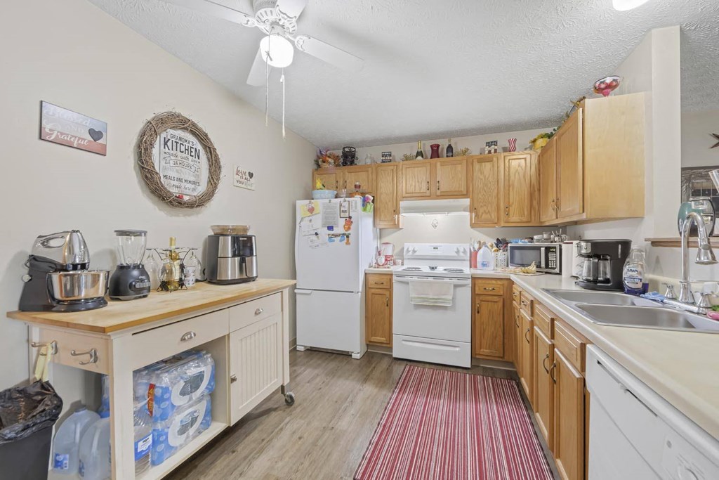 a kitchen with white appliances and wooden cabinets