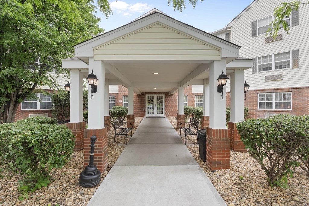 a sidewalk in front of a building with a covered walkway