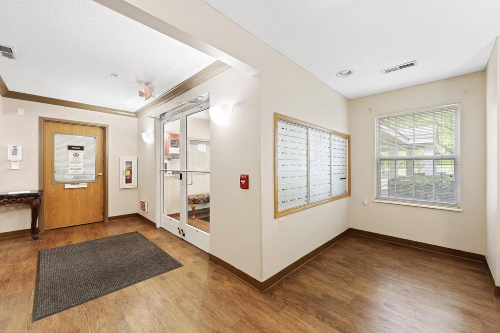 the living room of a house with wood floors and white walls