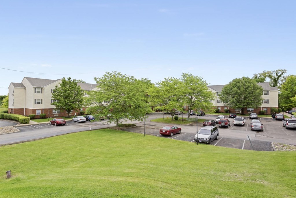 an aerial view of an apartment complex with cars parked in a parking lot