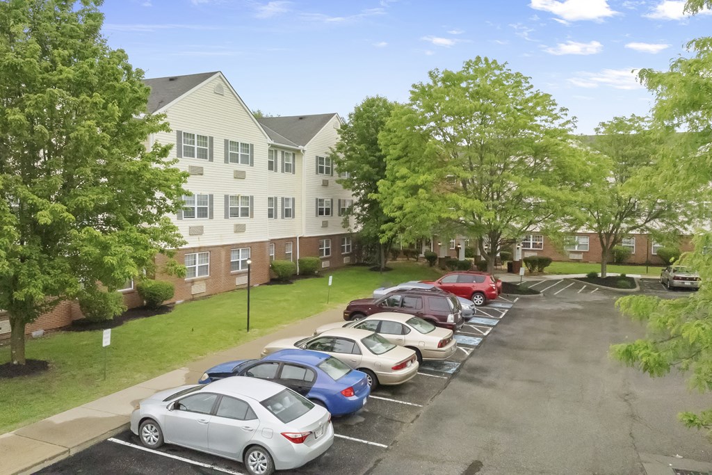 the apartment complex has a parking lot full of cars