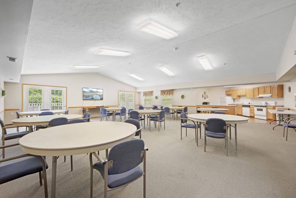 a dining room with tables and chairs and a kitchen