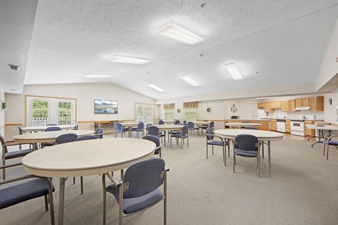 a dining room with tables and chairs and a kitchen