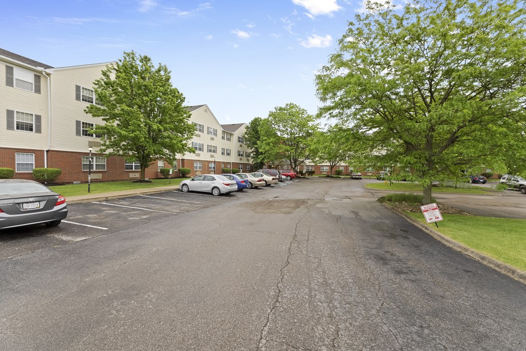 a parking lot with cars parked in front of apartment buildings