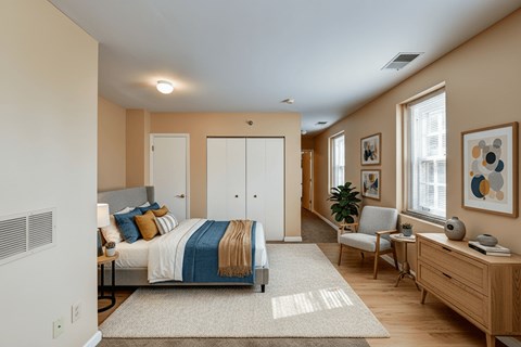 A bedroom with a bed, chair, and a painting on the wall.