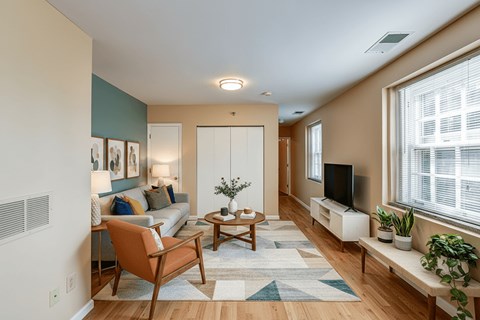 A living room with a couch, chair, and television.