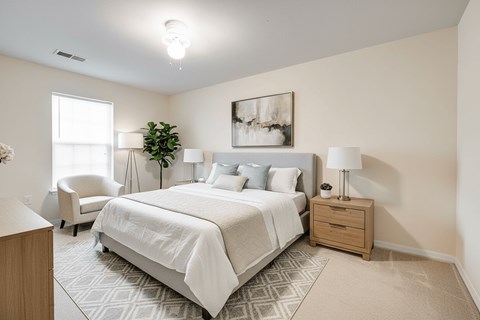 A bedroom with a large bed and a chair.