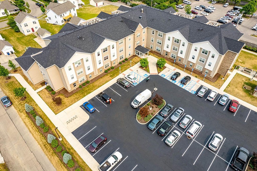 an aerial view of a large apartment complex with cars parked in the parking lot