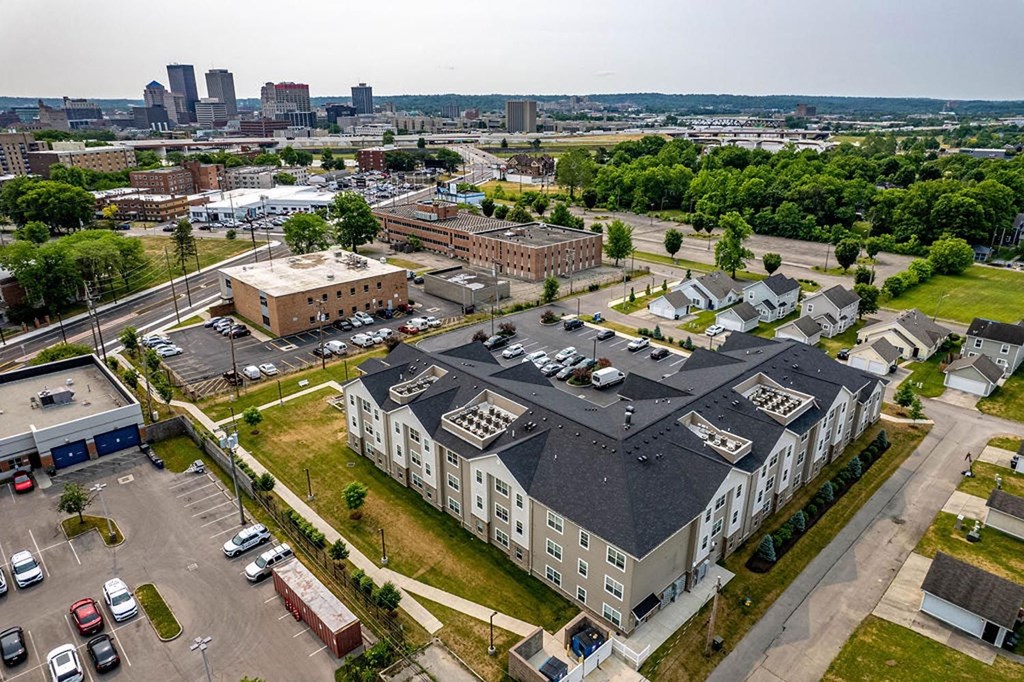 a large building with a gray roof and a parking lot in front of it