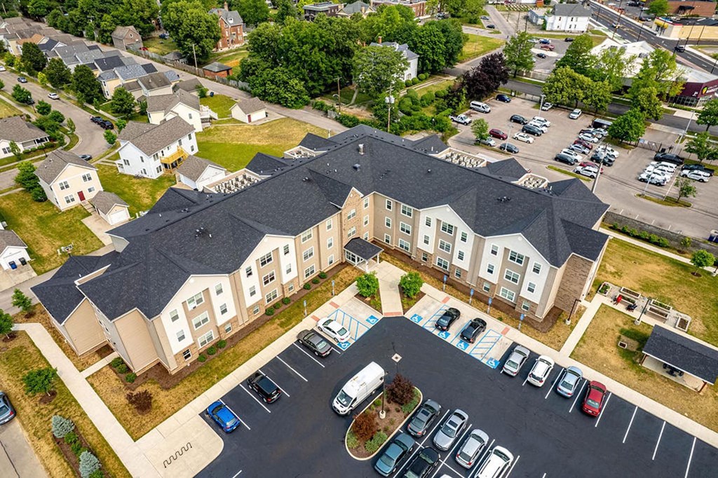 a large apartment complex with a parking lot and grassy area