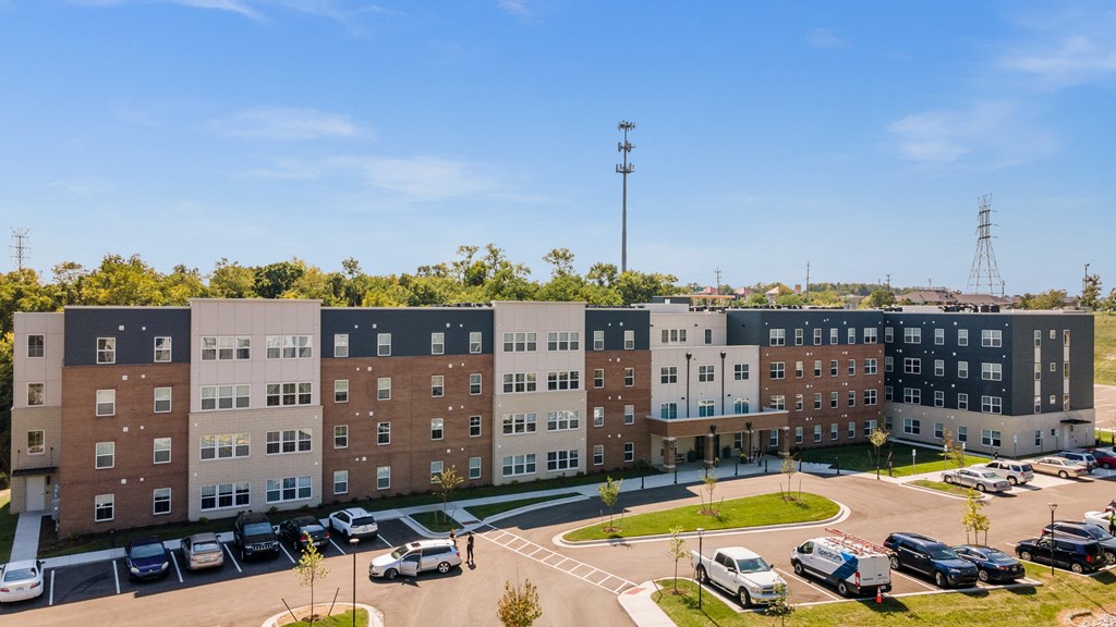 an aerial view of an apartment complex with cars parked in a parking lot