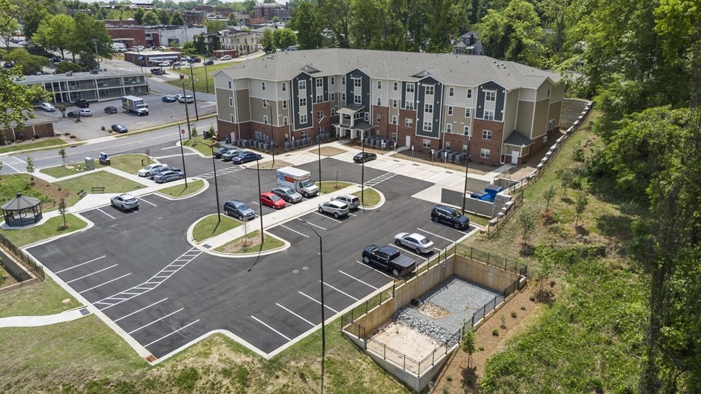 A parking lot with cars and a building in the background.