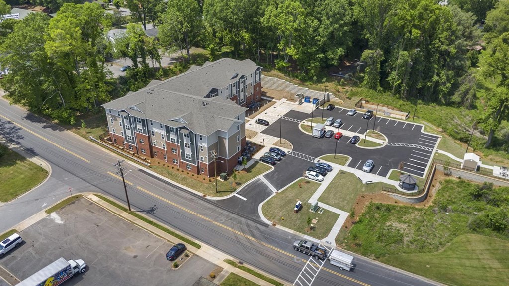 An aerial view of a parking lot and a building with a red brick exterior.