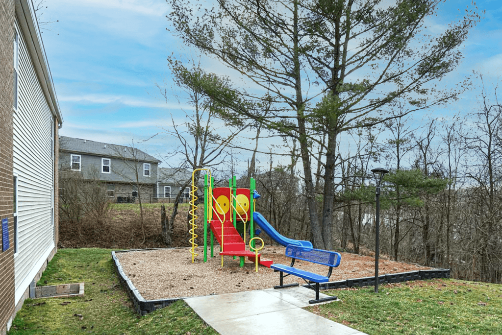 the childrens play area has a playground and a swing set