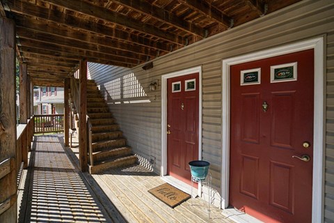 the front porch of a home with red doors and stairs