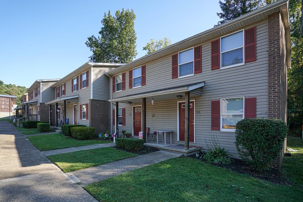 a row of apartments with red doors and sidewalks