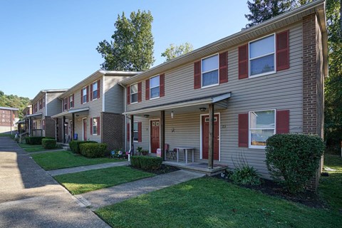 a row of apartments with red doors and sidewalks